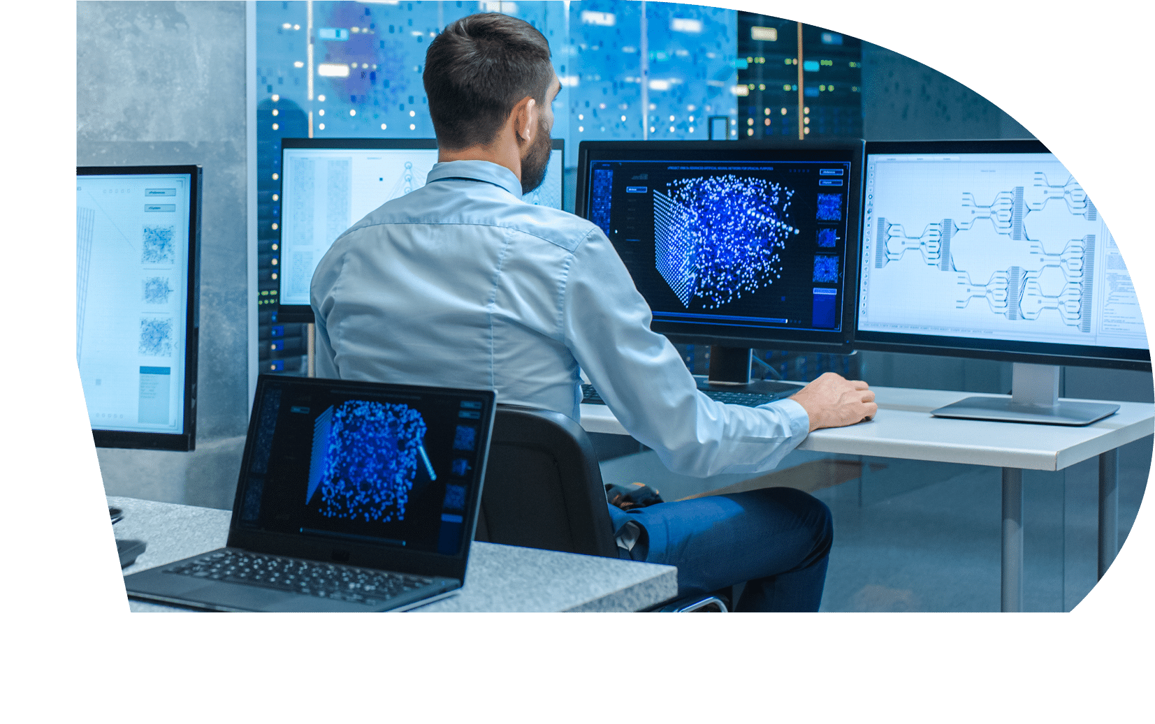 Beautiful Male Computer Engineer and Scientists Create Neural Network at His Workstation. Office is Full of Displays Showing 3D Representations of Neural Networks.